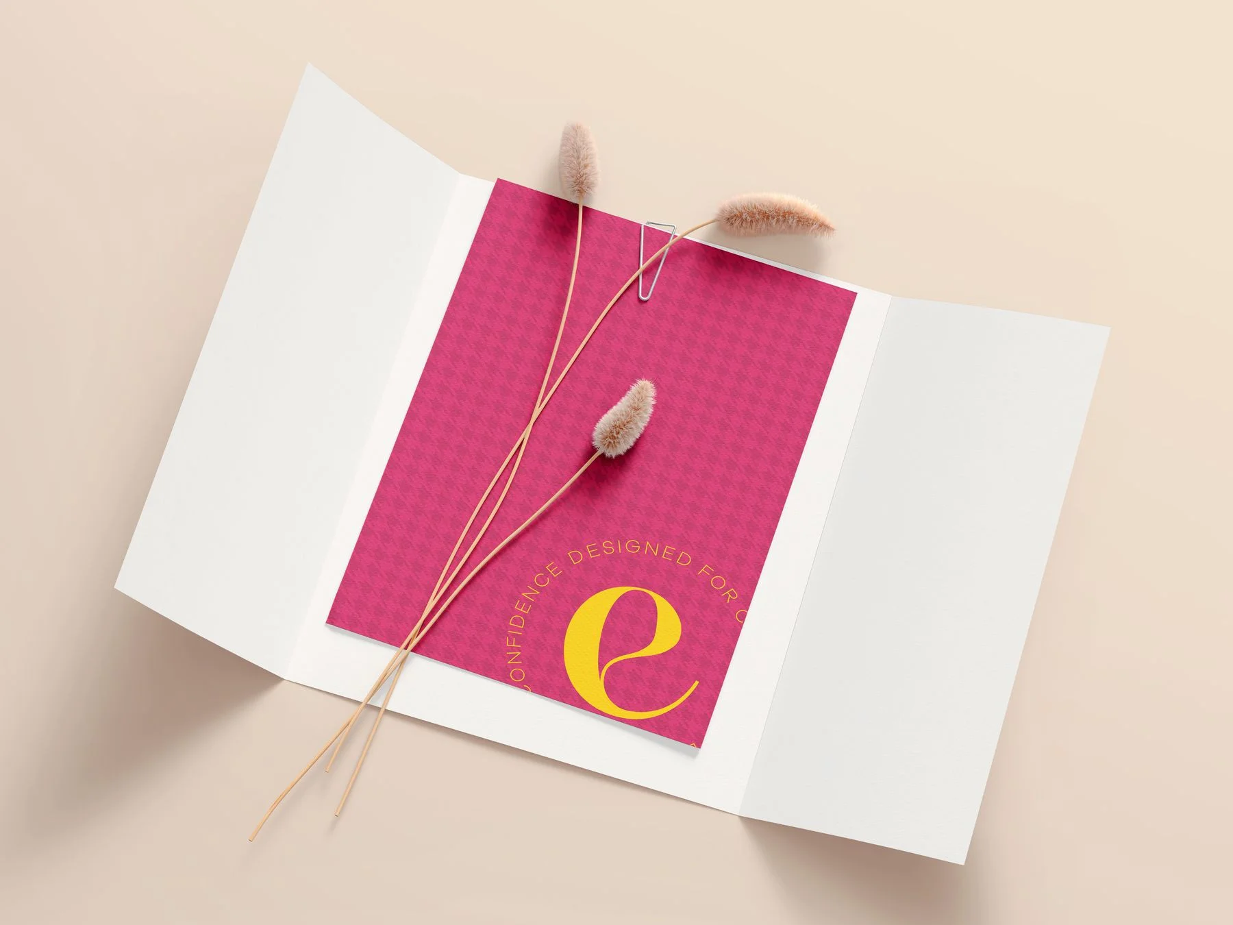 Carte Esthella framboise posée sur une pochette, avec des herbes séchées